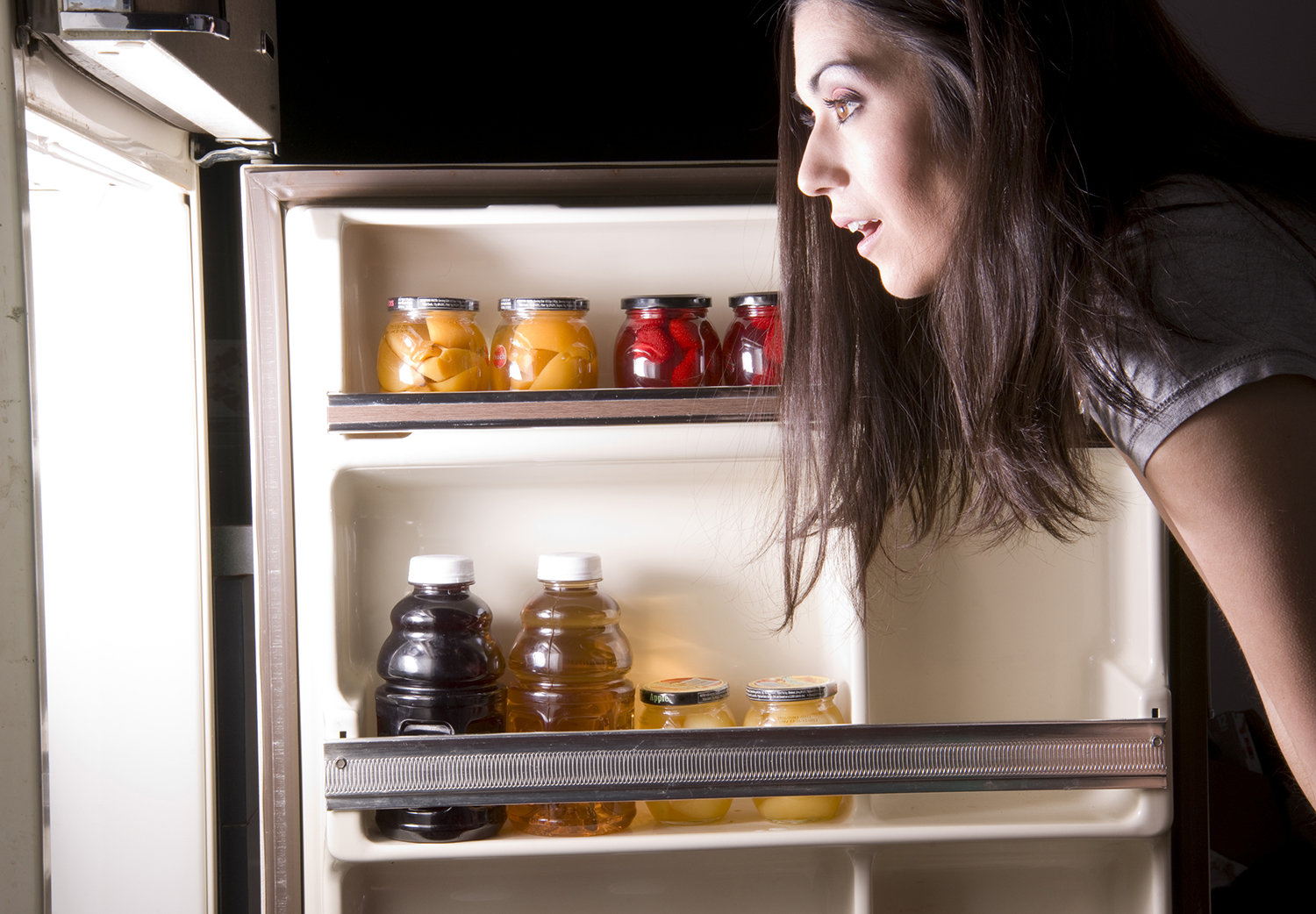 A woman raids the refrigerator late at night