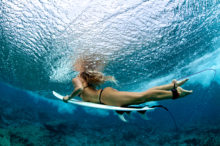 female surfer duck diving a wave
