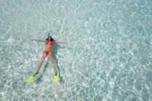 miami woman floating on crystal clear water