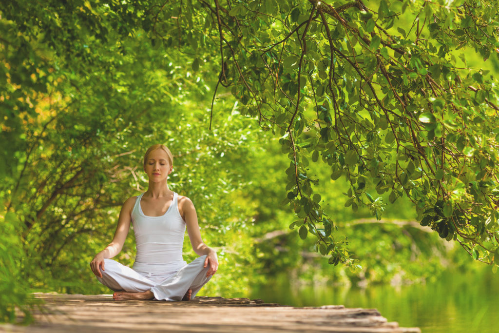 woman-meditating-lakeside