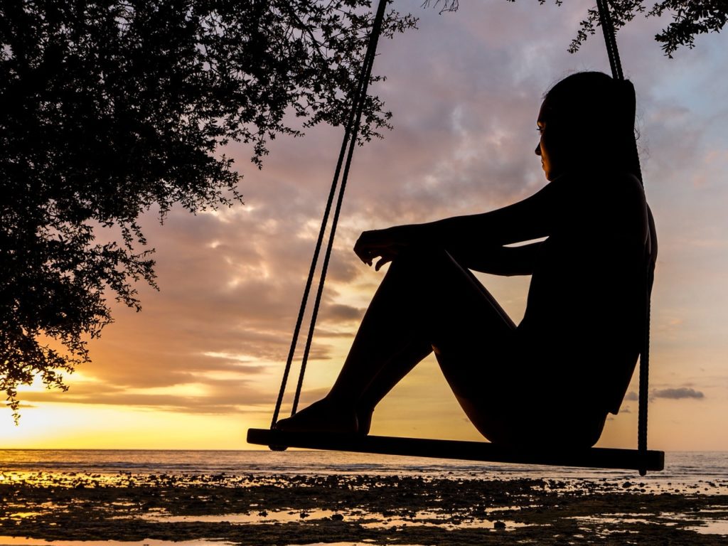 woman-swinging-sunset