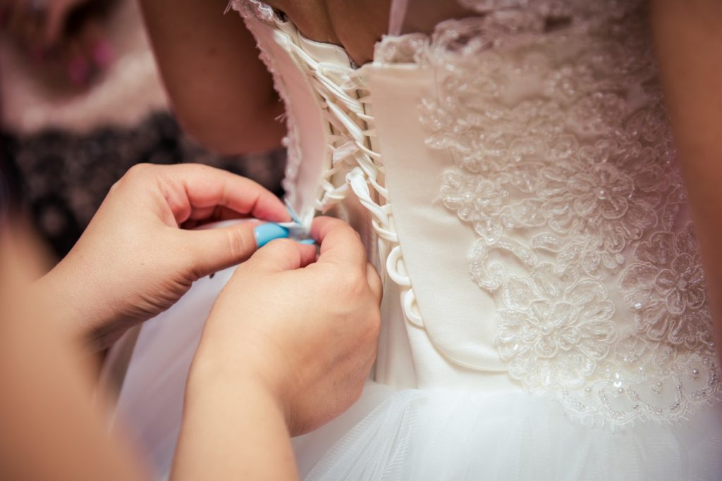 woman-lacing-wedding-gown