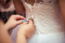 woman-lacing-wedding-gown